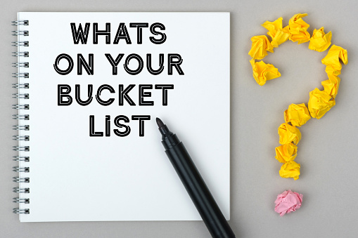 Hand With Marker Writing: Whats On Your Bucket List. Notepad And Question Mark.